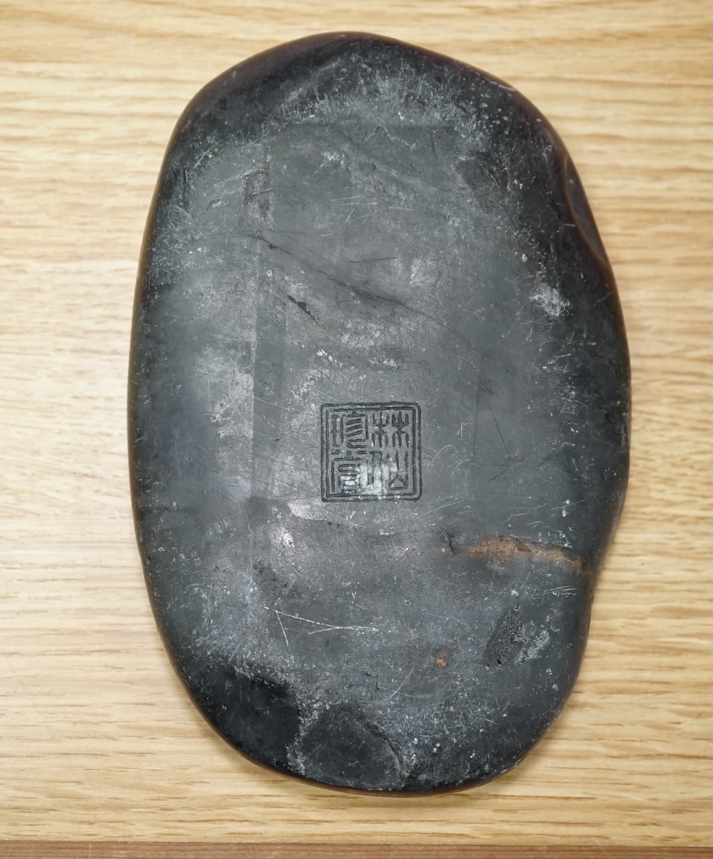 A Chinese literati ink stone with calligraphy, 16cm wide. Condition - fair